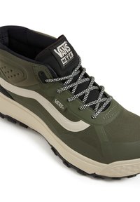 Olive green Vans MTE sneaker with a textured upper, white stripe, black and white checkered laces, and rugged black sole for traction.