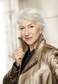 Veste en cuir doré avec fermeture éclair sur le devant, col pressionné et poches sur les côtés. Cheveux argentés courts et décoiffés avec un maquillage neutre.