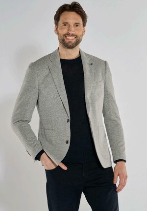 Grey knit blazer with a textured pattern, single button closure, notch lapels, and two front pockets, worn over a dark sweater.
