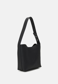 Černá ramenní taška vyrobená z hladké tkaniny, s minimalistickým designem, jedním popruhem a otevřeným vrchem s zakřiveným okrajem.
