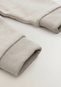 Polsini di felpa in cotone grigio chiaro con una texture a coste, caratterizzati da una finitura morbida e liscia e bordi cuciti in modo ordinato.