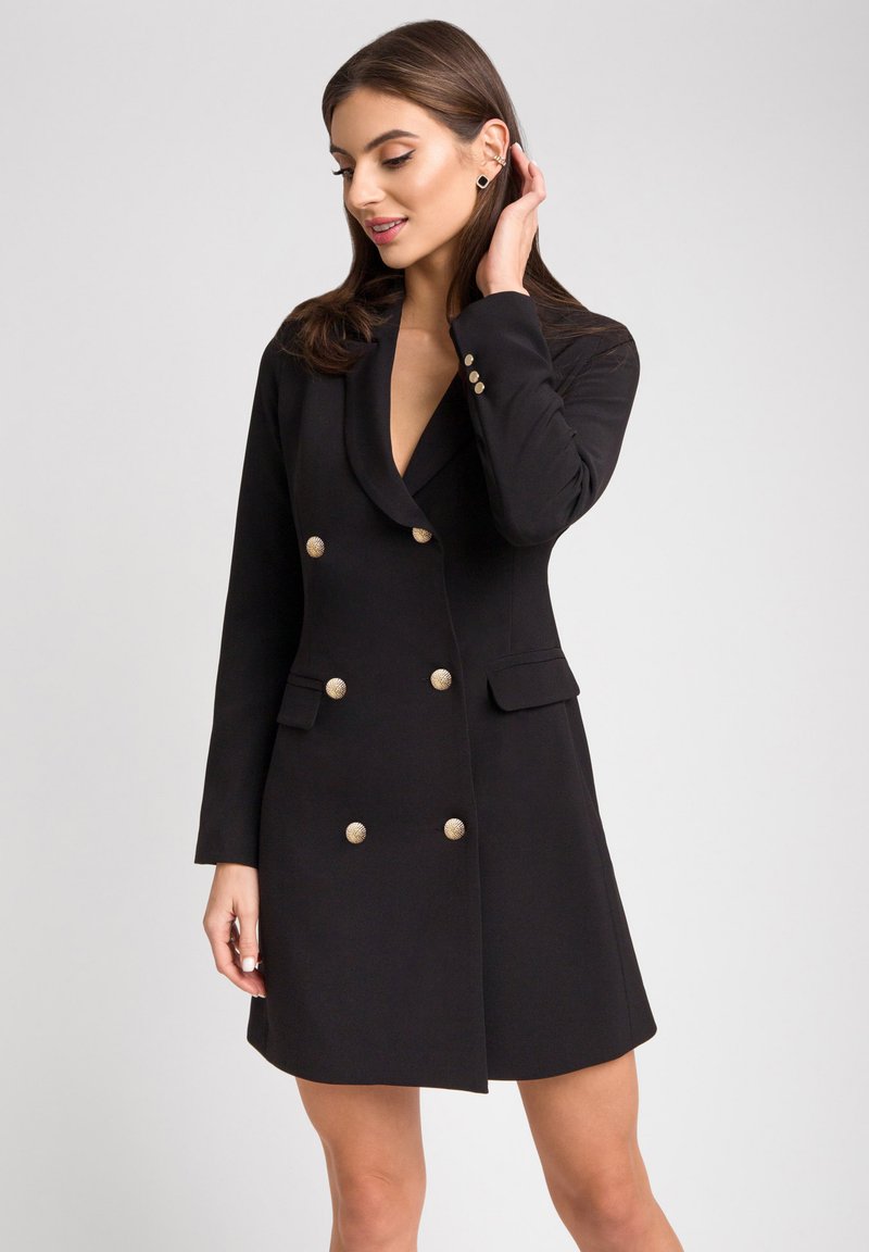 Czarny dwurzędowy płaszcz z srebrnymi guzikami, kołnierz z klapami oraz dwoma przednimi kieszeniami. Dopasowany krój z długimi rękawami i gładką fakturą.