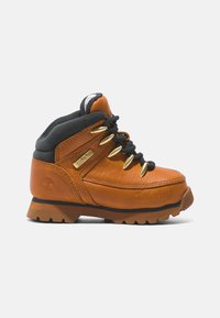 Bota de senderismo de cuero marrón con acentos grises, ojales dorados, suela de goma texturizada y detalle de logo en el lateral. Cuenta con un cuello acolchado.
