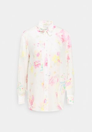 Camisa blanca de manga larga con un patrón floral en rosa, amarillo y azul. Cuello con volantes y lazo, cierre de botones en la parte delantera.