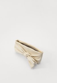 Kremfarget clutch-veske laget av mykt materiale, med en knyttet design foran og glidelås lukking på toppen.