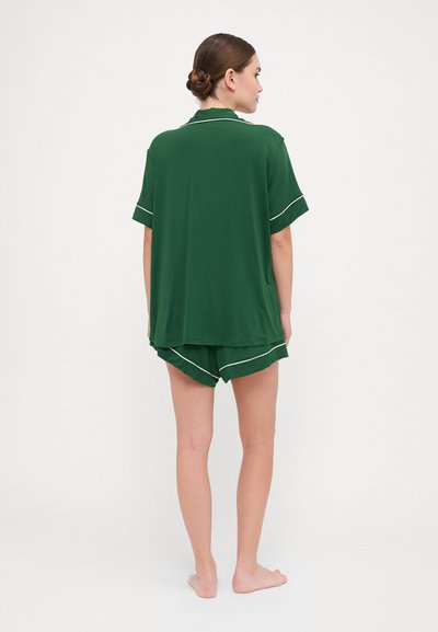 Conjunto de pijama verde de manga curta com uma camisa de colarinho e calções combinando com acabamento branco. Tecido suave com um corte descontraído.