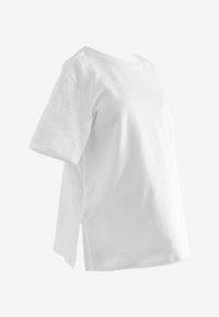 Witte kortarmige t-shirt gemaakt van katoen. Heeft een ronde halslijn en zijsplitten voor gemakkelijke beweging. Soepele textuur, losse pasvorm.