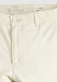Pantalon chino Levi's coupe loose off-white XX avec fermeture à bouton et passants pour ceinture, taille W32 L32.