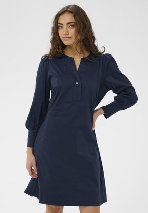 Granatowa sukienka z lekkiego materiału, z kołnierzykiem, detalami z guzikami i długimi, bufkowatymi rękawami.