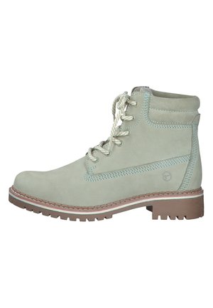 Bottes chelsea en suède vert menthe avec un bout rond, surface texturée, couture contrastante et semelle en caoutchouc robuste. Présente un design à lacets.