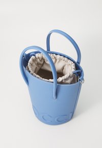 Borsa a secchiello blu in pelle con chiusura a coulisse, dotata di una fodera interna beige e dettaglio del logo in rilievo all'esterno. Due manici.