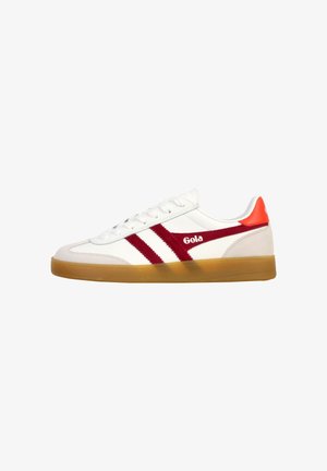 Sneaker blanche avec des rayures latérales rouges, une semelle en caoutchouc et un onglet de talon rouge, arborant le logo "Gola" sur le côté.