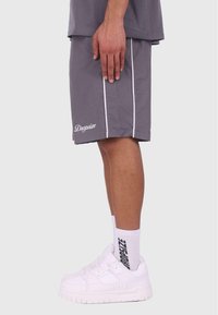Grå shorts med hvide striber og logo, parret med hvide sneakers og ankelstrømper med teksten "Dropesize" i sort.