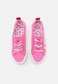 Une paire de baskets en toile Levi's roses avec des semelles en caoutchouc blanches, des lacets blancs et des semelles intérieures à imprimé léopard dans des tons roses et bleus.