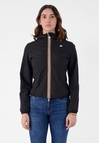Giacca nera con zip e cappuccio, caratterizzata da una cerniera a strisce colorate e un piccolo logo. Realizzata in materiale leggero e liscio.