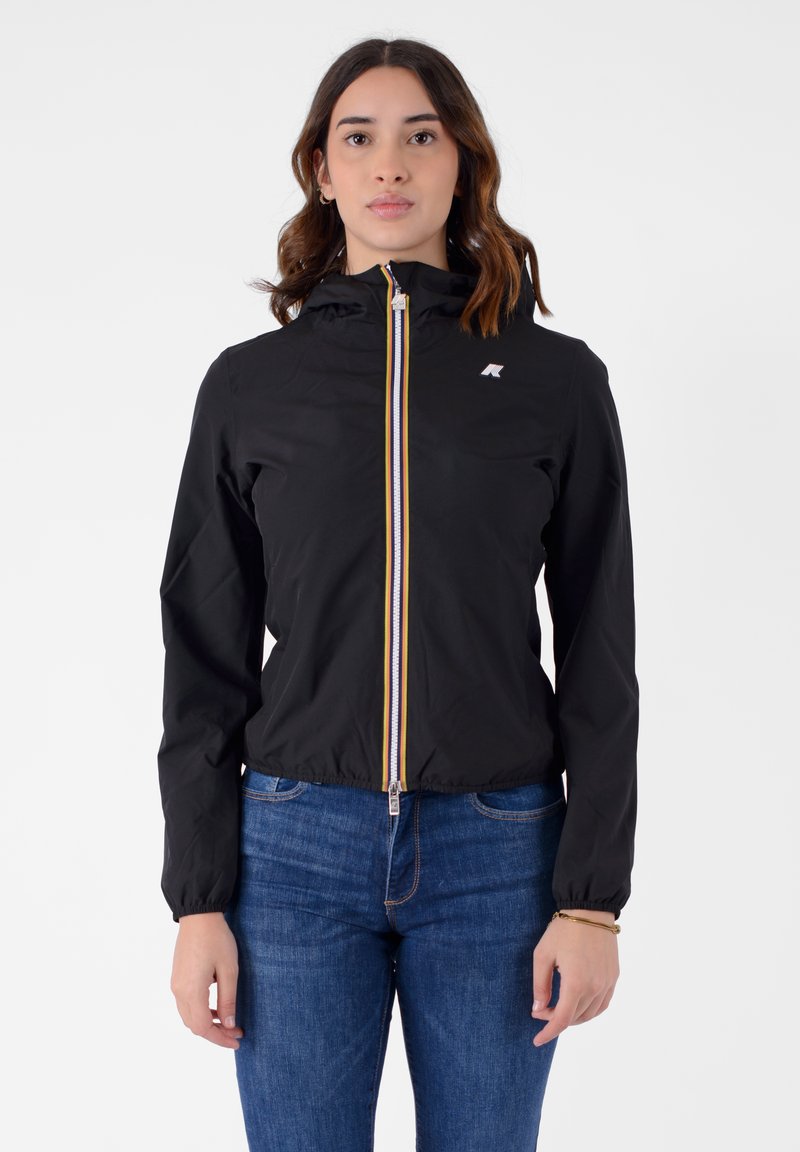 Giacca nera con zip e cappuccio, caratterizzata da una cerniera a strisce colorate e un piccolo logo. Realizzata in materiale leggero e liscio.