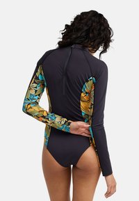 Πρόφυλακας εξανθήματος με μακριά μανίκια, ψηλό λαιμό και μείγμα μαύρου υφάσματος σώματος με πολύχρωμα λουλουδένια σχέδια στα μανίκια.