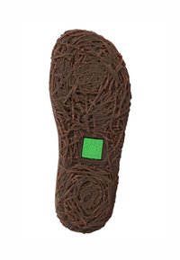 Suela de goma marrón con un acabado texturizado que recuerda a ramitas. Presenta un cuadrado verde con un logotipo de rana. Forma redondeada y ergonómica.