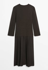 Czarny dzianinowy top z długim rękawem przymocowany do rozkloszowanej czarnej spódnicy, prezentowany na płasko na białym tle.