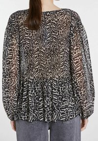 Blusa nera e beige a fantasia con tessuto leggero e trasparente, maniche lunghe, retro plissettato e scollo gathered.