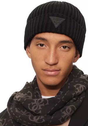 Bonnet côtelé noir avec un motif texturé, arborant un patch logo noir en forme de triangle. Accompagné d'une écharpe noire à motif.