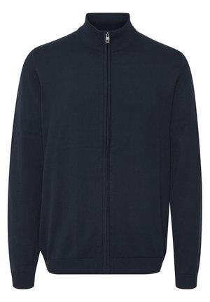 Cárdigan de cremallera en color navy, elaborado en tejido de punto. Presenta un cuello alto, mangas largas y puños y dobladillo acanalados. Textura suave y diseño minimalista.