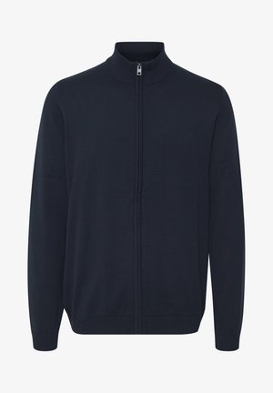 Marine blå zip-up cardigan laget av strikket stoff. Har høy krage, lange ermer og ribbede mansjetter og kant. Glatt tekstur, minimalistisk design.