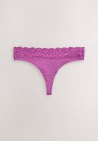 Lilla g-streng med en bred, bølget blondekant og glat stof. Har et minimalistisk design og en tynd stoftekstur.