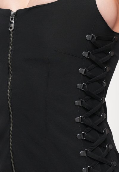 Black dress featuring a front zipper and side lace-up detail with metallic loops. Smooth fabric with a fitted design.