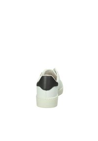 Sneaker bianco con un accent di tallone nero, tomaia in pelle liscia, punta arrotondata e suola testurizzata. La vista posteriore mostra una cucitura curva sul tallone.