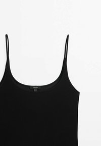 Débardeur noir avec des bretelles spaghetti fines, encolure ronde et texture côtelée. Étiquette visible à l'intérieur avec les informations de taille.