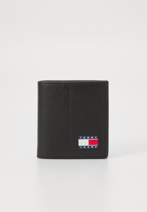 Portefeuille en cuir noir avec un patch logo coloré aux accents bleu, rouge et blanc. Texture lisse et détails de couture verticale visibles.