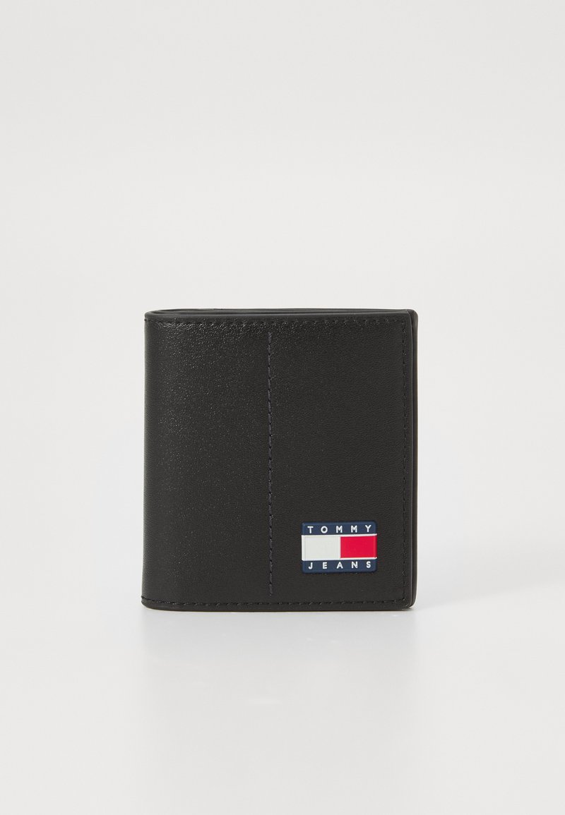 Black leather wallet featuring a colored logo patch with blue, red, and white accents. Smooth texture and a vertical stitch detail visible.