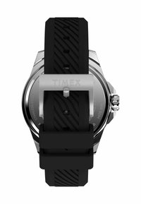 Montre avec bracelet en caoutchouc noir et boîtier en acier inoxydable, affichant un cadran épuré. Comprend une boucle avec le gravage "TIMEX" et une résistance à l'eau.