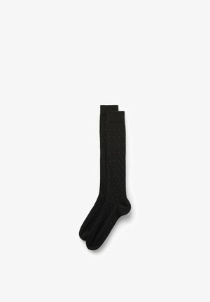 Calcetines negros hasta la rodilla con textura acanalada, decorados con pequeños lunares rojos y azules distribuidos de manera uniforme por toda la superficie.
