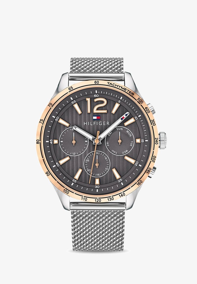 Montre argentée avec un cadran texturé gris, dotée d'une lunette dorée et d'un bracelet en mailles. Les indicateurs comprennent des sous-cadrans pour le jour et la date.