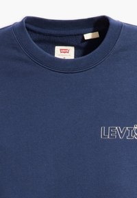 Felpa di cotone blu navy con collo rotondo, caratterizzata da un logo ricamato bianco "LEVI'S" sulla parte anteriore e un'etichetta all'interno del colletto.
