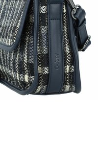 Sac à main rayé bleu marine et crème en tissu tissé avec une finition en cuir, comportant un fermoir à rabat et un accent en métal argenté.