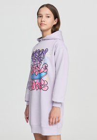 Lila sukienka z kapturem i długimi rękawami, z kolorowym nadrukiem tekstu i bazgrołów z przodu. Miękka faktura tkaniny, długość do kolan.