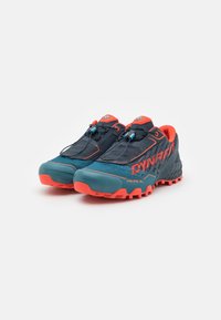 Chaussures de trail en bleu foncé avec des accents orange, dotées d'une tige en mesh, de lacets sécurisés, d'une semelle rembourrée et de semelles texturées pour une meilleure adhérence.