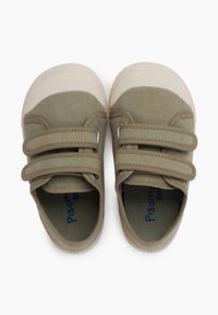 Scarpe in tela verde oliva con suole in gomma beige, doppie fascette in velcro e punta arrotondata. L'interno presenta un testo di branding blu.