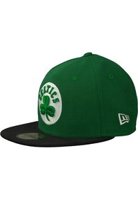 Gorra verde ajustada con visera negra, que presenta un parche circular blanco con la palabra "CELTICS" y un emblema de trébol verde.