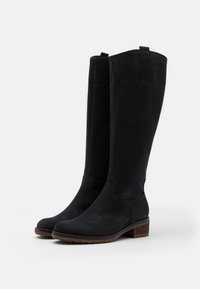 Botas negras hasta la rodilla de ante, con punta redondeada, acabado texturizado y un tacón de madera bajo. Incluye lengüetas en la parte superior.