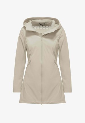 Beige lange softshelljas met capuchon, een volledige ritssluiting aan de voorkant en ritssluitingen aan de zijkanten, ontworpen voor een slanke pasvorm.