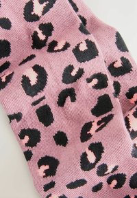 Różowe skarpetki w leopardzi wzór z czarnymi plamami i jasnoróżowymi akcentami. Wykonane z miękkiego, teksturowanego materiału.