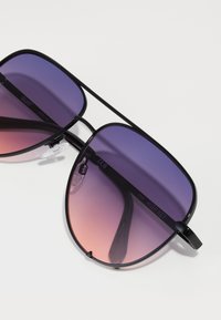 Schwarze Piloten-Sonnenbrille mit Farbverlauf von lila zu pinken Gläsern, ausgestattet mit transparenten Nasenpolstern und gravierten Markendetails am Gestell.