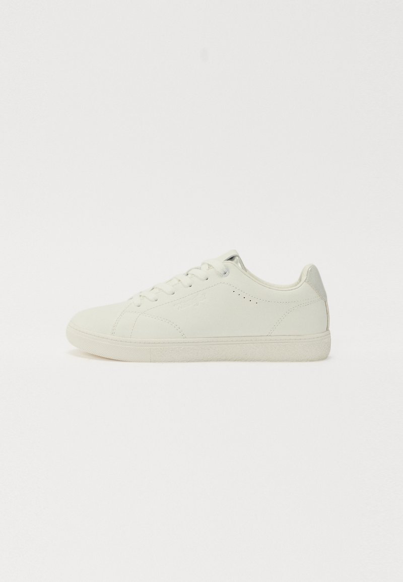 Baltas ādas čības ar gludu apdari, noapaļota purngala forma un sešiem acu caurumiem. Satur smalkas perforācijas un strukturētu gumijas zoli.