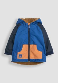 Blå og marineblå jakke med orange lomme, featuring en lynlås lukning og en hætte foret med brun pels-lignende tekstur. Inkluderer brandmærke.