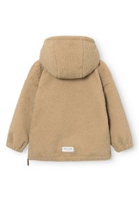 Veste polaire beige à capuche avec manches longues, poignets élastiques et une petite étiquette rectangulaire près du bas du dos.