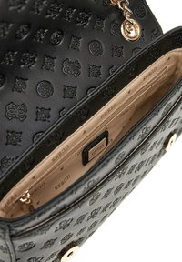 Borsa a mano in pelle nera con impresso, dotata di hardware in tonalità oro, con un interno beige e una tasca con zip per l'organizzazione.